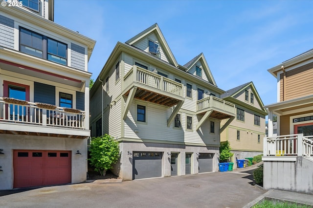 view of front of house with a garage, a balcony, and asphalt driveway