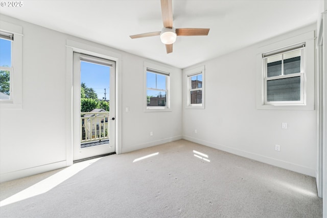 empty room with plenty of natural light, carpet flooring, ceiling fan, and baseboards