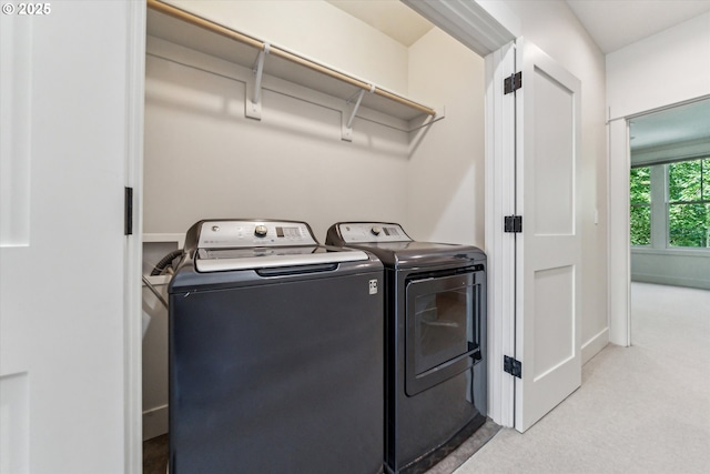 laundry area with washing machine and dryer and light colored carpet
