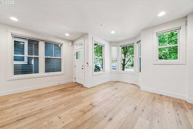 unfurnished room with baseboards, hardwood / wood-style floors, healthy amount of natural light, and recessed lighting