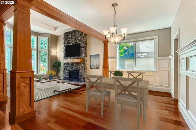 14702 SE Badger Creek Rd, Happy Valley, OR 97086 - dining room with ornate columns, wood finished floors, a chandelier, a decorative wall, and a wainscoted wall