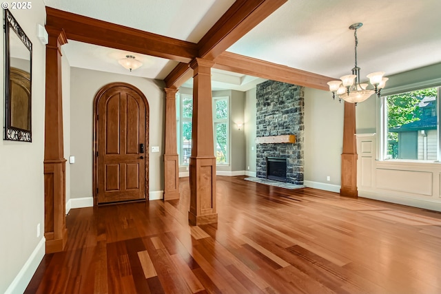 14702 SE Badger Creek Rd, Happy Valley, OR 97086 - foyer entrance with wood finished floors, ornate columns, a stone fireplace, a chandelier, and beam ceiling