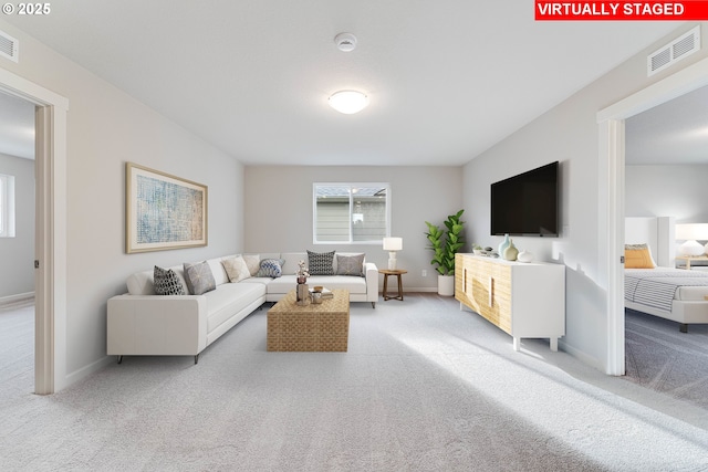 living area with baseboards, visible vents, and carpet flooring