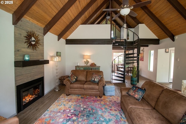 1896 W Park Dr, Florence, OR 97439 - living room featuring wood ceiling with exposed beams, a glass covered fireplace, stairs, wood finished floors, and high vaulted ceiling