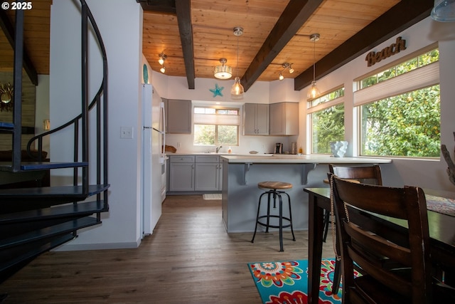 1896 W Park Dr, Florence, OR 97439 - kitchen with wooden ceiling with exposed beams, gray cabinetry, a kitchen breakfast bar, dark wood-style floors, and a sink