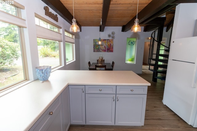 1896 W Park Dr, Florence, OR 97439 - kitchen with freestanding refrigerator, wood ceiling with exposed beams, a peninsula, light countertops, and dark wood-style flooring