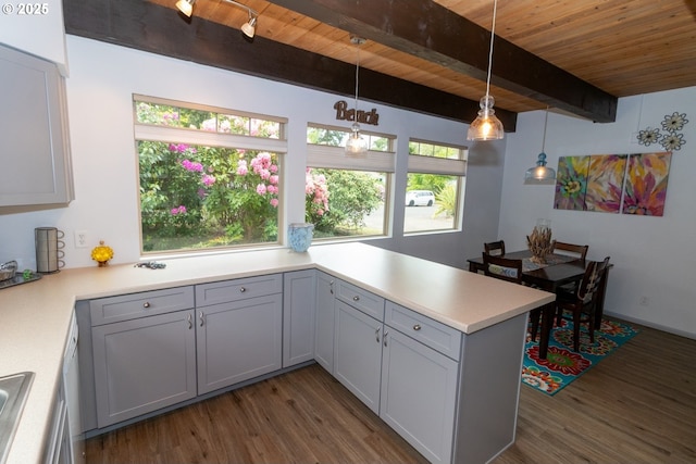 1896 W Park Dr, Florence, OR 97439 - kitchen featuring wood ceiling with exposed beams, dark wood-style floors, a peninsula, light countertops, and pendant lighting