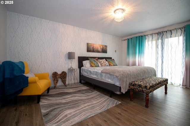 1896 W Park Dr, Florence, OR 97439 - bedroom with wallpapered walls, wood finished floors, and a textured ceiling