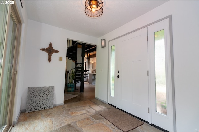 1896 W Park Dr, Florence, OR 97439 - entryway with stone floors, healthy amount of natural light, stairs, and baseboards