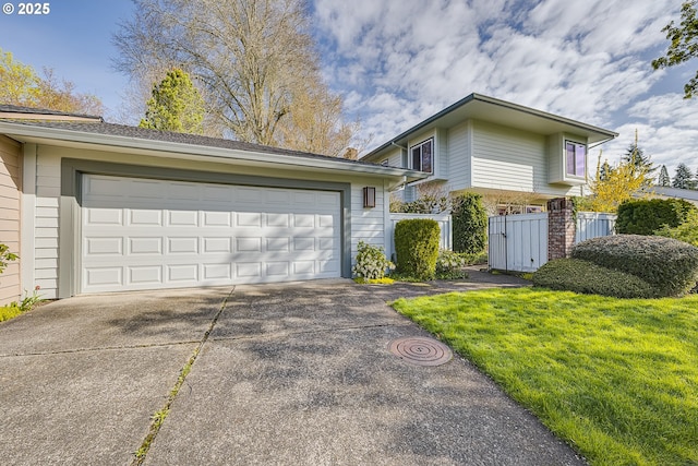 view of front of home featuring a garage, a front lawn, fence, and concrete driveway
