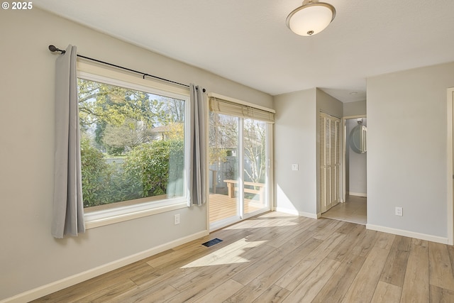 spare room featuring visible vents, baseboards, and wood finished floors