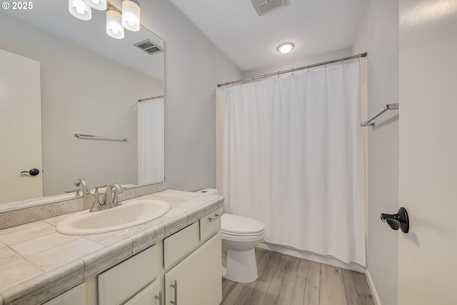 bathroom featuring vanity, visible vents, toilet, and wood finished floors