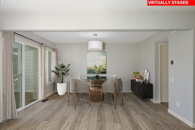 dining space featuring baseboards and wood finished floors