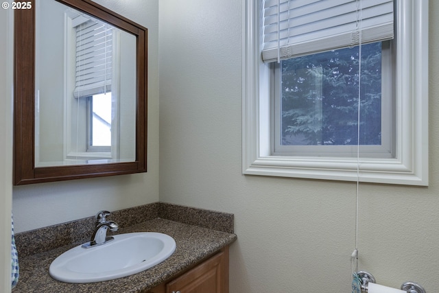 bathroom featuring vanity and a textured wall