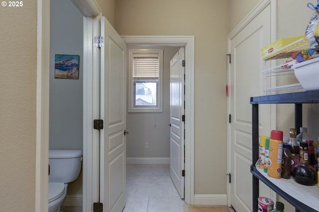 hall with baseboards and light tile patterned flooring