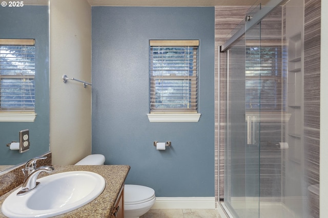 full bath featuring tile patterned flooring, a shower stall, baseboards, toilet, and vanity