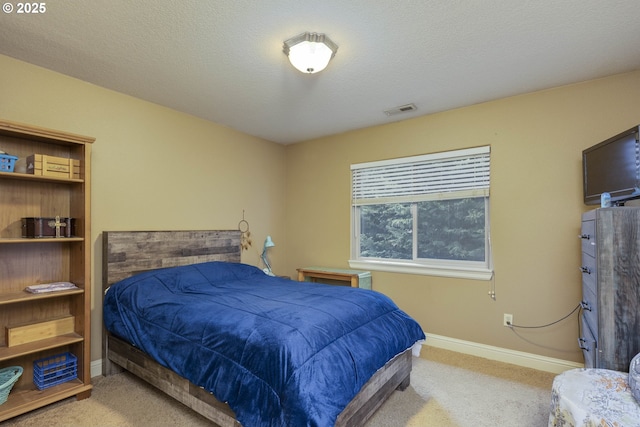 bedroom featuring visible vents, carpet flooring, a textured ceiling, and baseboards