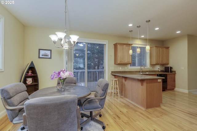 dining room with recessed lighting, baseboards, a notable chandelier, and light wood-style flooring