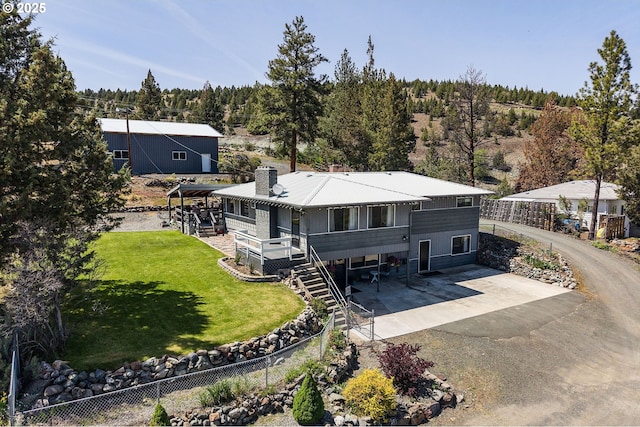 204 Adam Dr, Canyon City, OR 97820 - view of front facade featuring a chimney, a patio, asphalt driveway, a forest view, and stairway