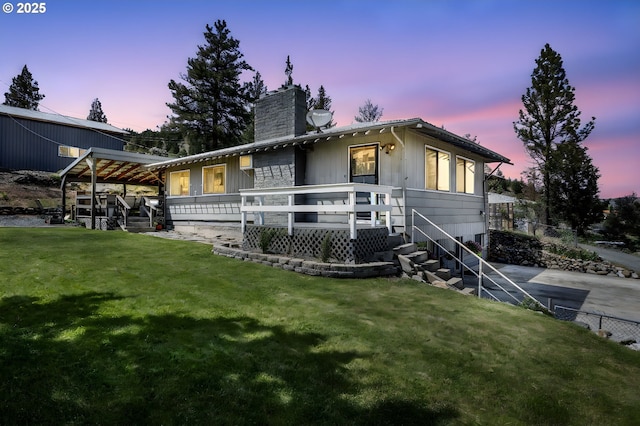 204 Adam Dr, Canyon City, OR 97820 - back of property at dusk featuring a chimney, a lawn, and a deck