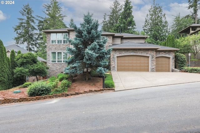 view of front facade with a garage, stone siding, and driveway