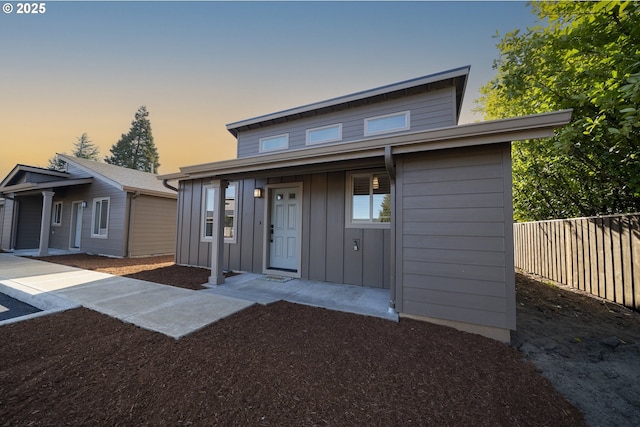 view of front of home with board and batten siding and fence