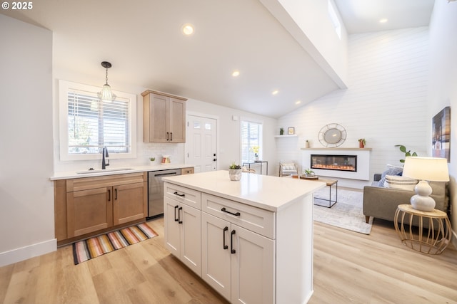 kitchen featuring dishwasher, open floor plan, hanging light fixtures, light countertops, and light brown cabinets