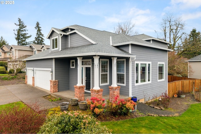 view of front facade featuring fence, roof with shingles, covered porch, a garage, and driveway