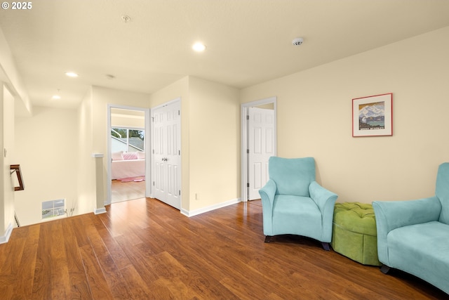 sitting room with recessed lighting, wood finished floors, visible vents, and baseboards