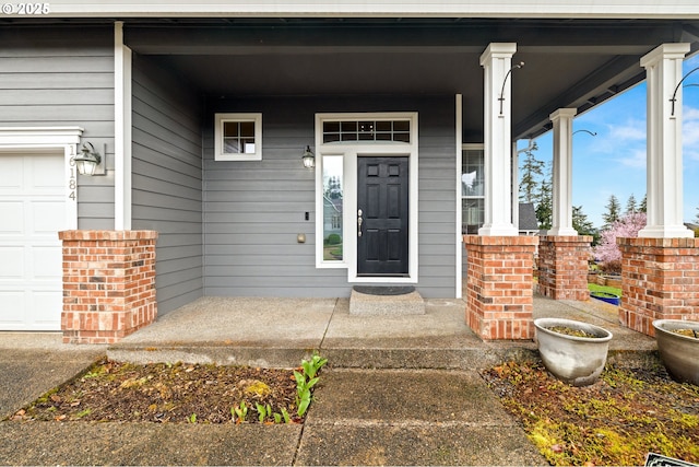 doorway to property featuring a garage and a porch