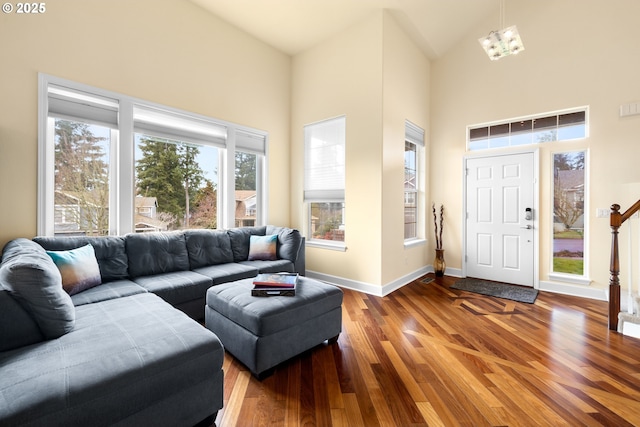 living area featuring baseboards, a high ceiling, and wood finished floors