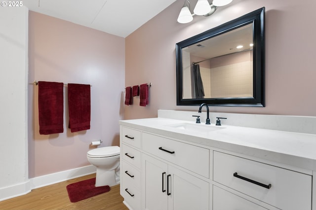bathroom featuring vanity, wood finished floors, toilet, baseboards, and a shower with curtain