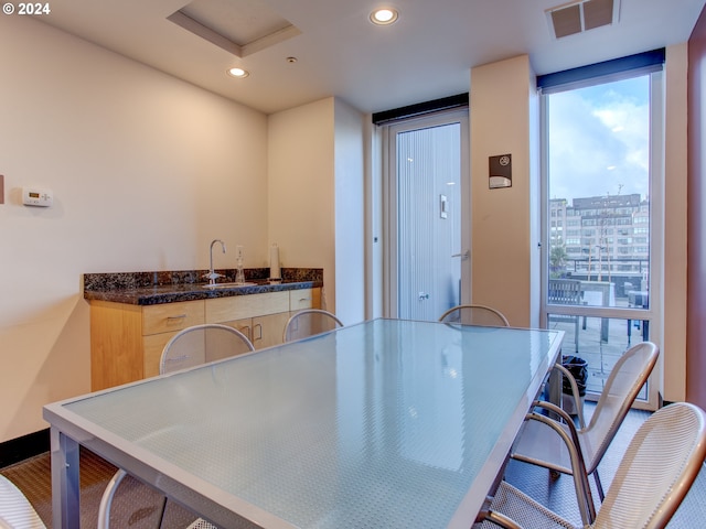 interior space featuring visible vents, a sink, recessed lighting, and dark countertops