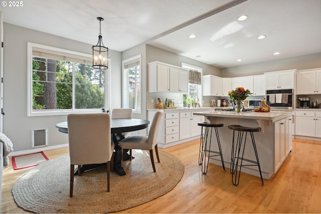 dining room featuring recessed lighting, light wood finished floors, and a chandelier