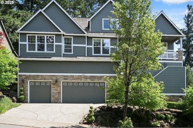 craftsman-style house featuring stone siding, driveway, and a garage