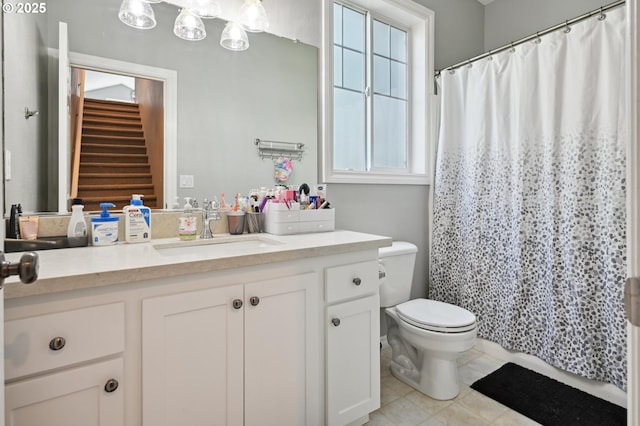 bathroom with toilet, vanity, and curtained shower