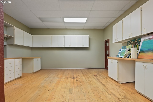 kitchen featuring a paneled ceiling, white cabinets, light wood-type flooring, and open shelves