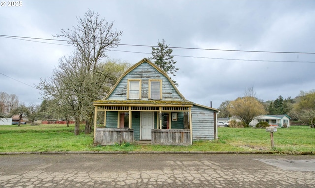 dutch colonial with a porch, a gambrel roof, and a front lawn