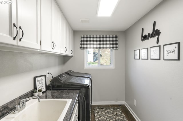 clothes washing area with cabinets, sink, independent washer and dryer, and dark hardwood / wood-style floors