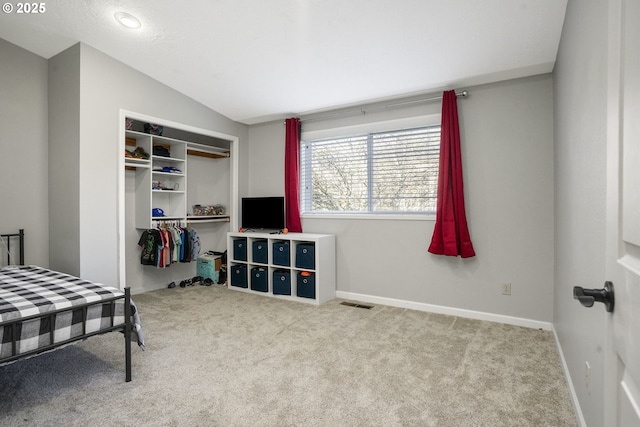 bedroom featuring lofted ceiling, light colored carpet, and a closet