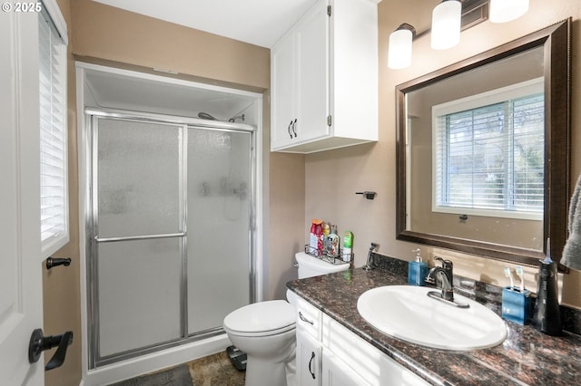 bathroom with an enclosed shower, vanity, and toilet