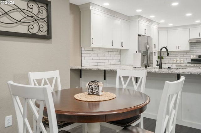 dining space featuring sink and dark hardwood / wood-style flooring