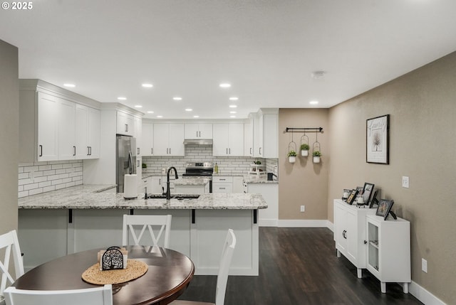 kitchen featuring appliances with stainless steel finishes, sink, white cabinets, and kitchen peninsula