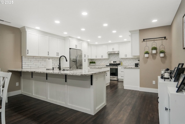 kitchen featuring sink, white cabinets, light stone counters, kitchen peninsula, and stainless steel appliances