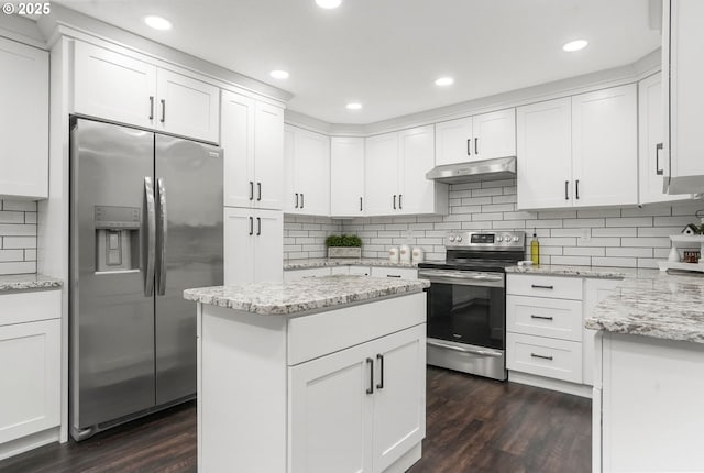 kitchen with stainless steel appliances, white cabinetry, light stone countertops, and dark hardwood / wood-style floors