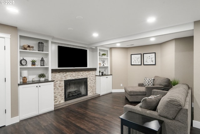 living room with dark wood-type flooring, a fireplace, and built in features