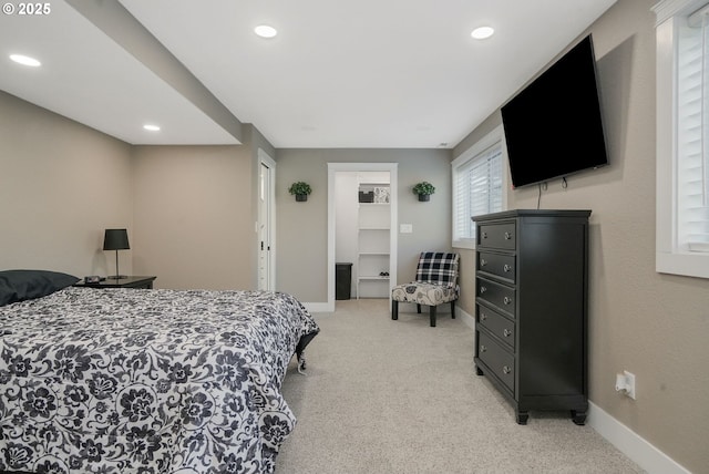 carpeted bedroom with a walk in closet