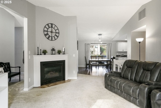 carpeted living room with vaulted ceiling