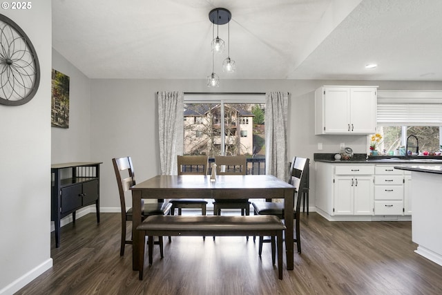 dining room with sink, dark hardwood / wood-style floors, and a textured ceiling