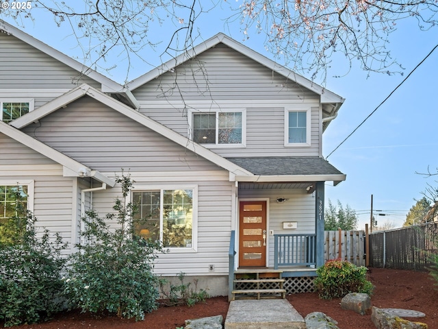 view of front of house featuring a shingled roof and fence